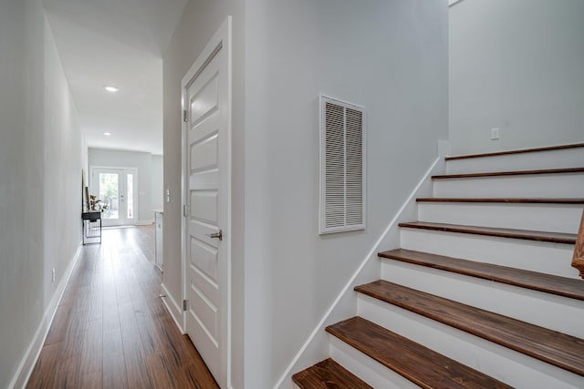 staircase featuring recessed lighting, visible vents, baseboards, and wood finished floors