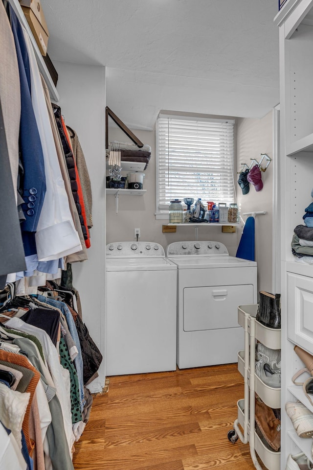 washroom featuring laundry area, light wood-type flooring, and washing machine and clothes dryer