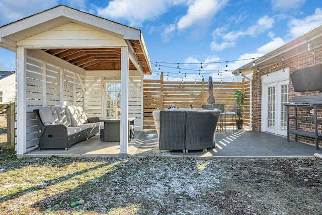 view of patio with fence, outdoor lounge area, and french doors