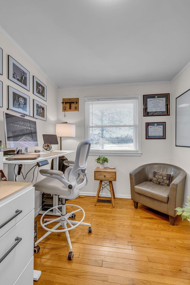 home office with light wood-type flooring, baseboards, and ornamental molding