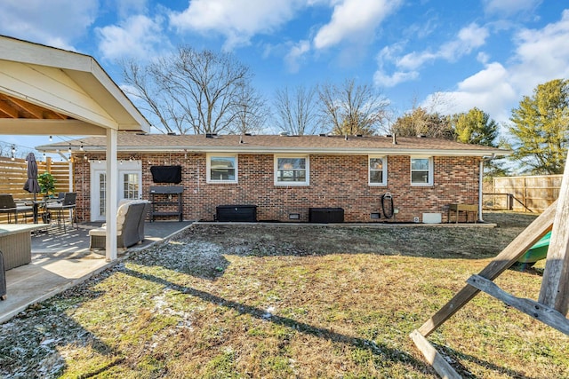 back of house featuring a yard, fence, a patio, and brick siding