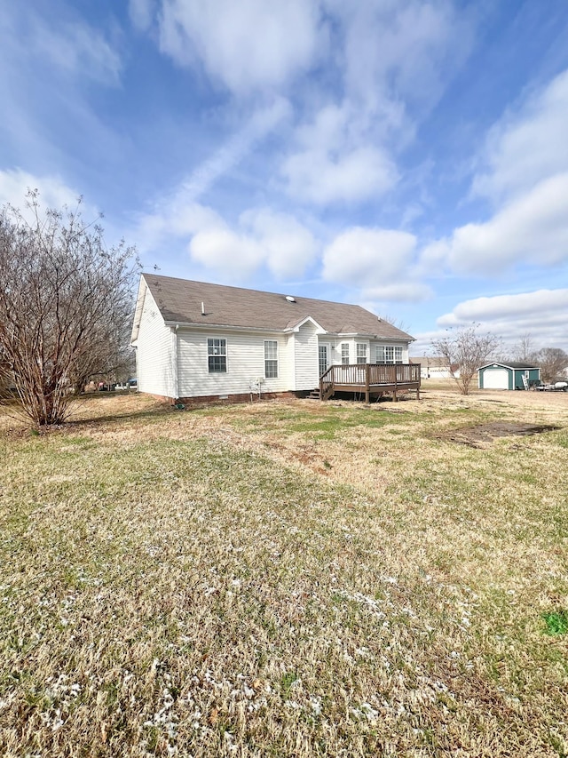 back of property with a lawn and a wooden deck