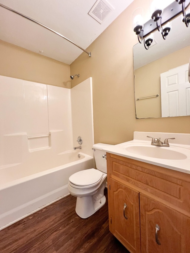 bathroom featuring shower / bathtub combination, visible vents, toilet, vanity, and wood finished floors