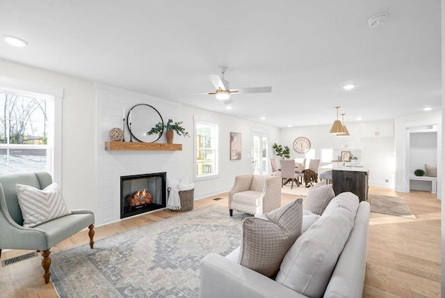 living room featuring recessed lighting, a healthy amount of sunlight, and light wood-style flooring