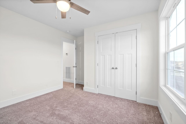 unfurnished bedroom featuring light carpet, visible vents, and baseboards