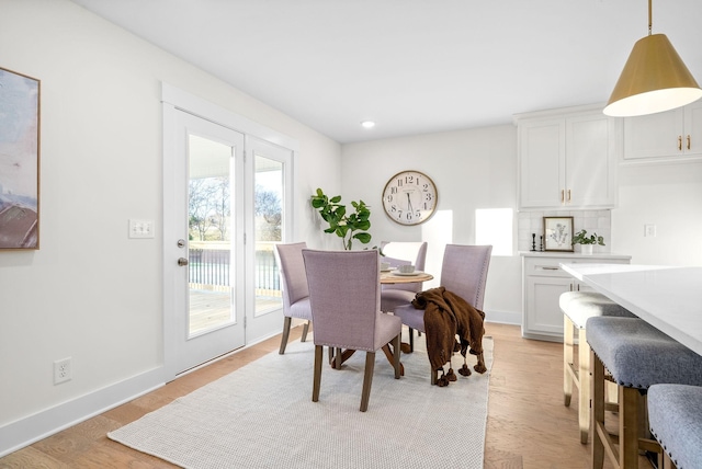 dining room with baseboards, recessed lighting, and light wood-style floors