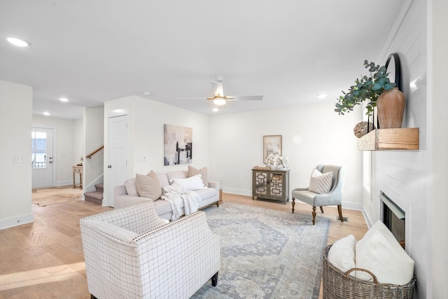 living room with recessed lighting, a fireplace, baseboards, stairway, and light wood-type flooring