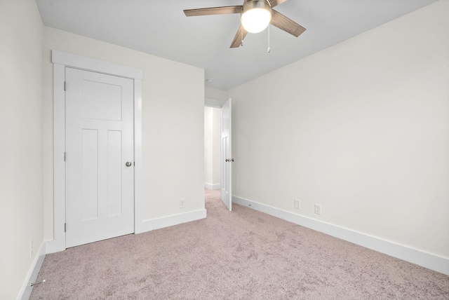 unfurnished bedroom featuring light carpet, ceiling fan, and baseboards