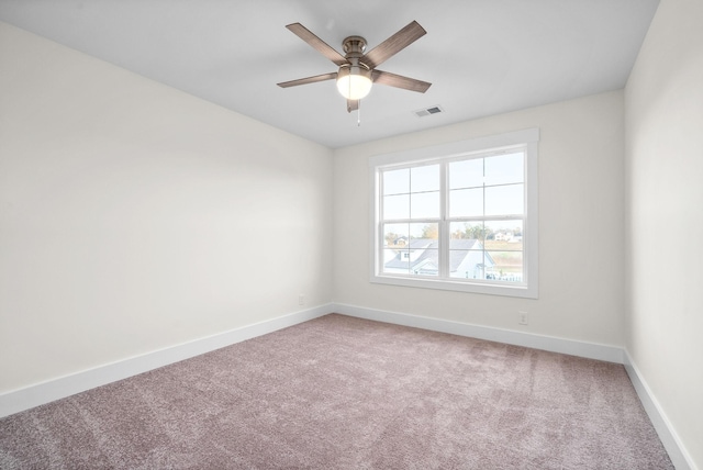 unfurnished room with visible vents, carpet, a ceiling fan, and baseboards