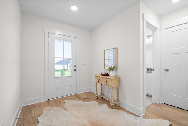 doorway with recessed lighting, baseboards, and light wood finished floors