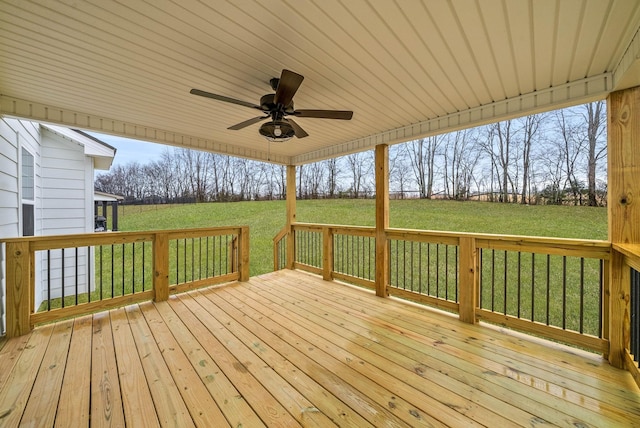 wooden deck with ceiling fan and a lawn