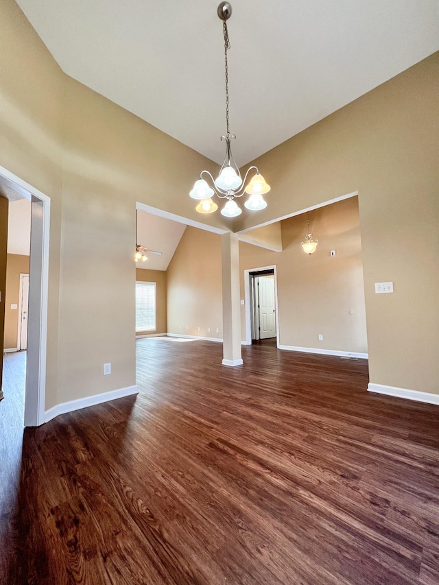 spare room with high vaulted ceiling, baseboards, and dark wood-style flooring