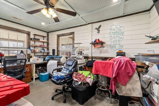 home office featuring a ceiling fan, visible vents, and unfinished concrete flooring