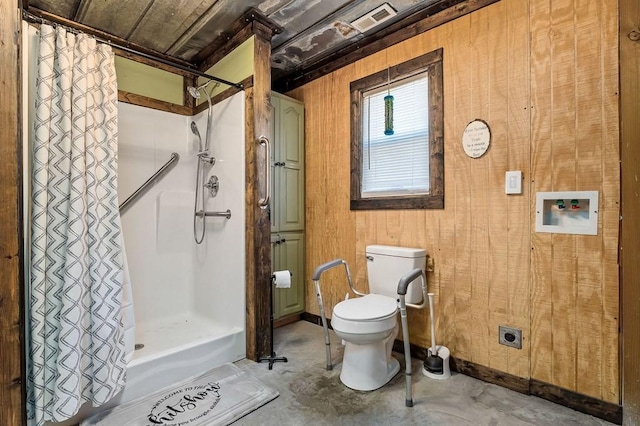 full bath with unfinished concrete floors, wood walls, toilet, and a shower with curtain