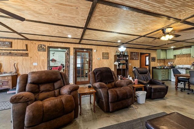 living room featuring wooden walls, wood ceiling, concrete floors, and a ceiling fan