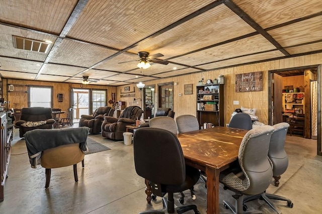 dining room with wooden ceiling, wooden walls, a ceiling fan, and concrete flooring