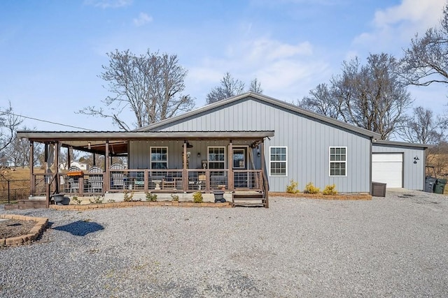 view of front of property with a porch, gravel driveway, board and batten siding, and a garage