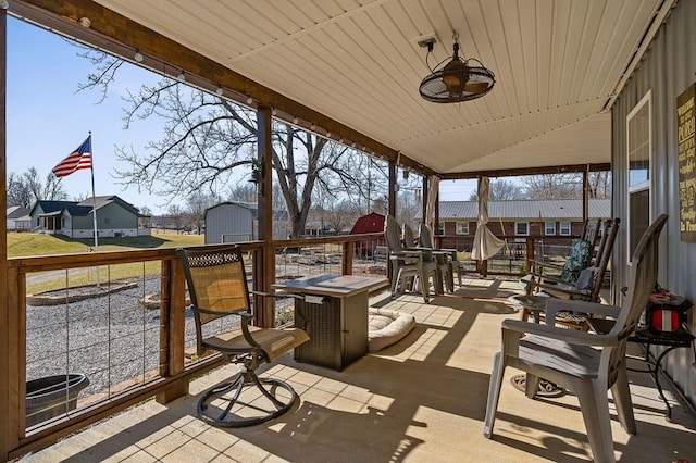 view of patio with a residential view, a fire pit, an outbuilding, and a shed