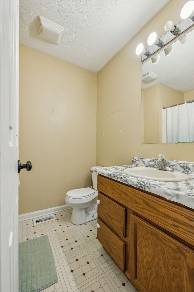 full bathroom with visible vents, toilet, tile patterned floors, a textured ceiling, and vanity