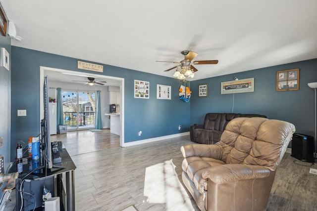 living room with ceiling fan, light wood-style flooring, and baseboards