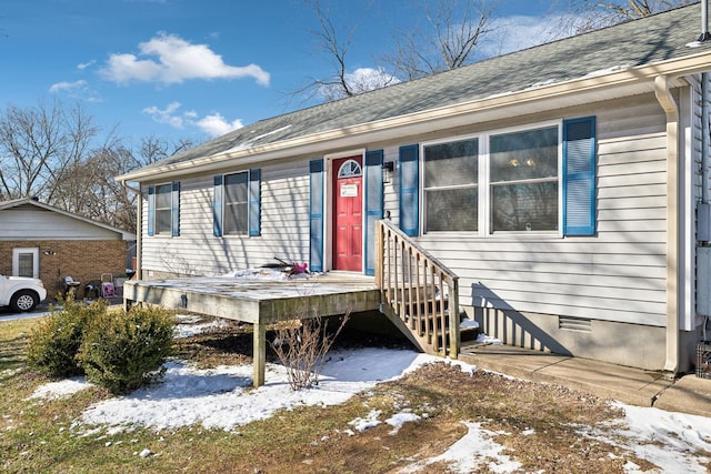 view of front of house featuring a shingled roof and crawl space