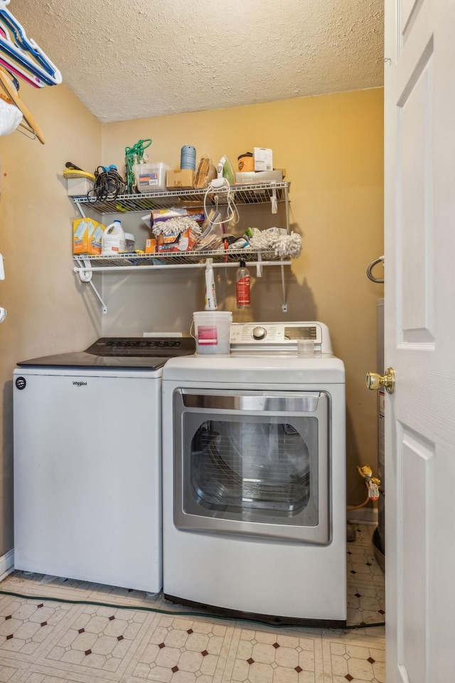 washroom featuring laundry area, a textured ceiling, light floors, and washer and dryer