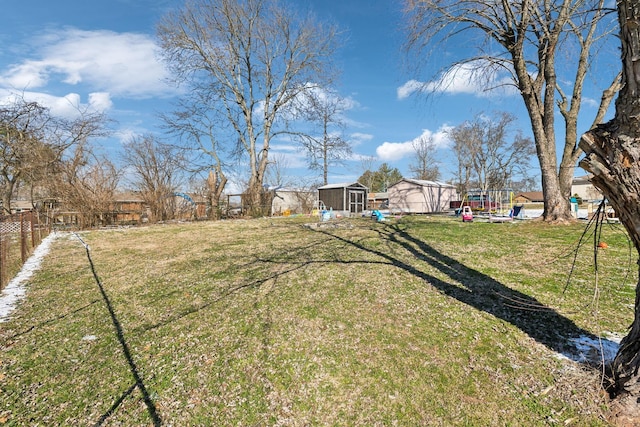 view of yard featuring fence and an outbuilding