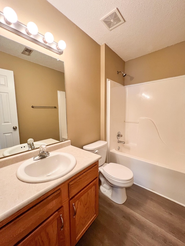 full bath featuring visible vents, toilet, shower / tub combination, wood finished floors, and a textured ceiling