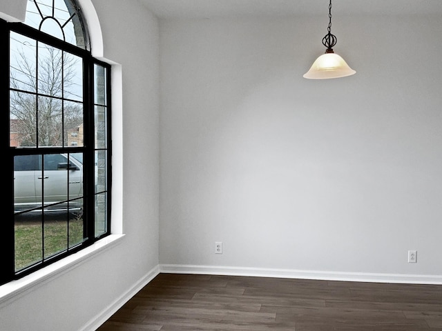 empty room with dark wood-type flooring and baseboards