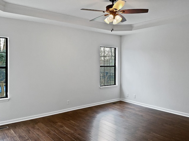 unfurnished room with visible vents, dark wood finished floors, baseboards, and ceiling fan