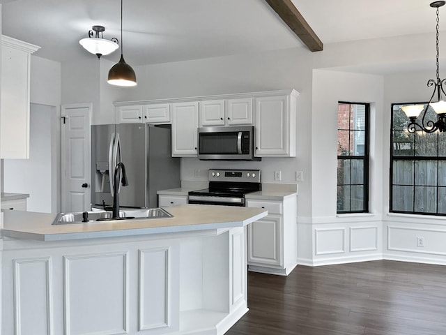 kitchen featuring light countertops, appliances with stainless steel finishes, white cabinets, and pendant lighting