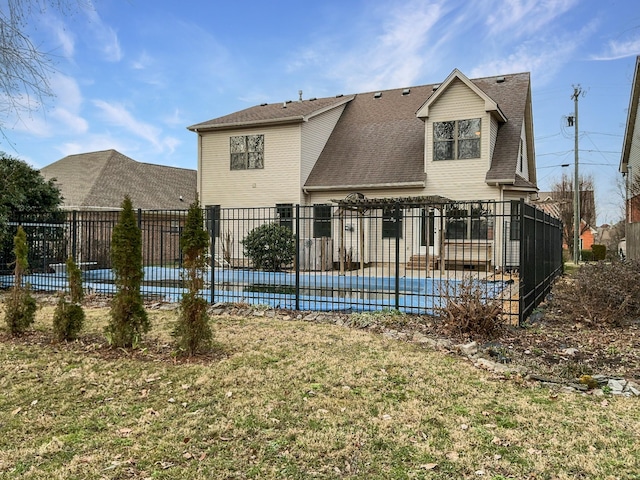 back of property featuring a yard, a patio area, fence, and a pool