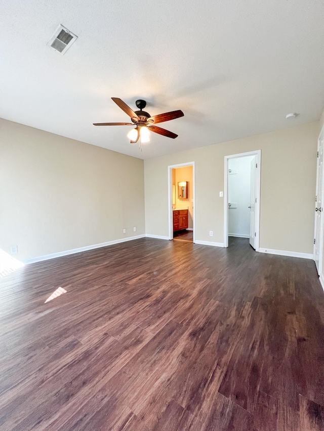 interior space with ceiling fan, dark wood-style flooring, visible vents, and baseboards