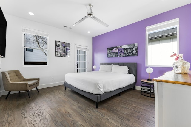 bedroom featuring visible vents, multiple windows, baseboards, and dark wood-style flooring