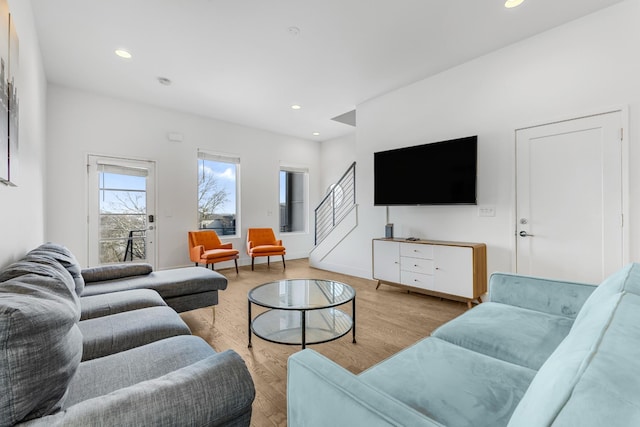 living room featuring light wood-type flooring, stairs, baseboards, and recessed lighting