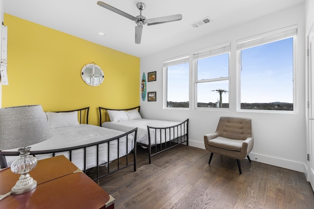 bedroom with dark wood-type flooring, multiple windows, visible vents, and baseboards