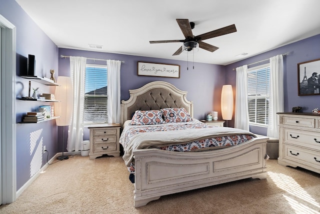 carpeted bedroom with multiple windows, visible vents, and a ceiling fan