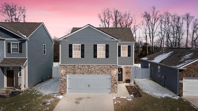 view of front facade with a garage, stone siding, and driveway