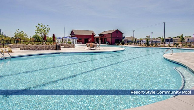 community pool with fence and a patio