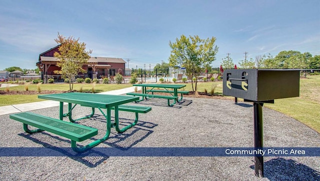 view of community featuring fence and a yard