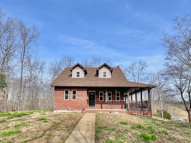 view of front of home with covered porch, brick siding, and a shingled roof