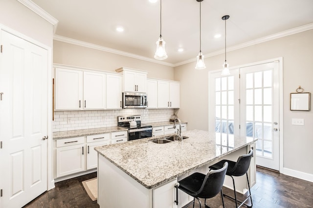 kitchen featuring white cabinetry, a center island with sink, and appliances with stainless steel finishes