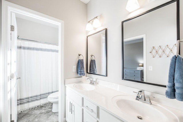 bathroom featuring a sink, toilet, and double vanity