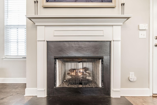 interior details featuring a fireplace with flush hearth and baseboards