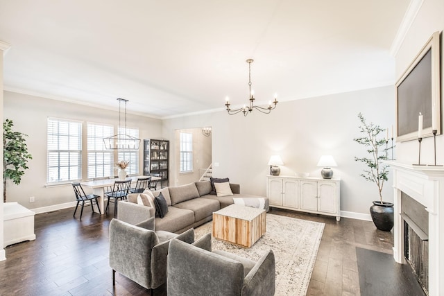 living area with dark wood-style floors, a fireplace, a chandelier, and crown molding