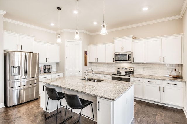 kitchen with a kitchen island with sink, appliances with stainless steel finishes, white cabinets, and a sink