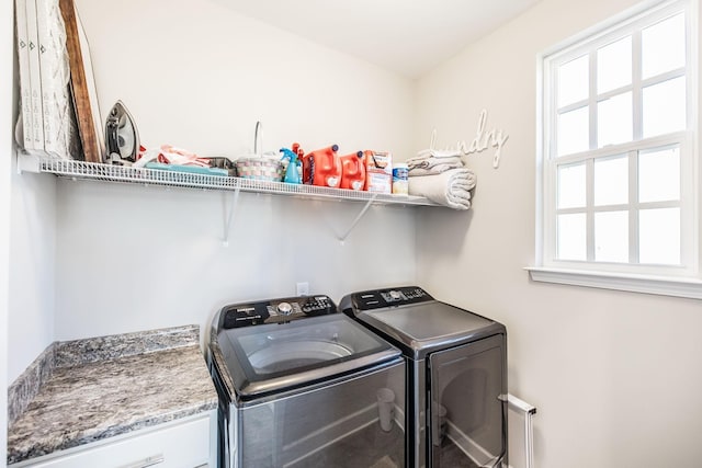 clothes washing area featuring a healthy amount of sunlight, laundry area, and washer and clothes dryer