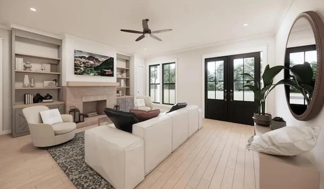 living area featuring light wood-type flooring, built in shelves, crown molding, and a tile fireplace