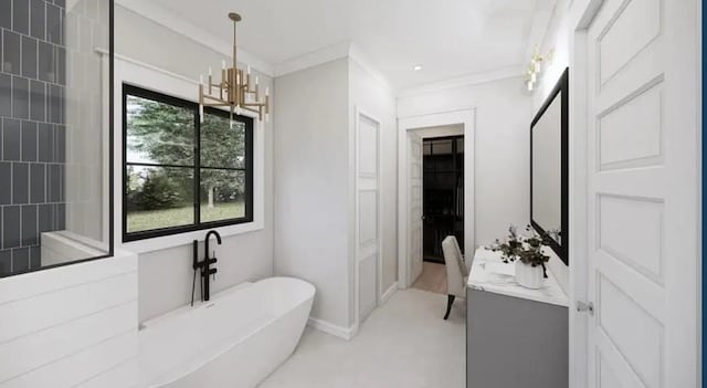 bathroom with baseboards, crown molding, vanity, a freestanding tub, and a notable chandelier