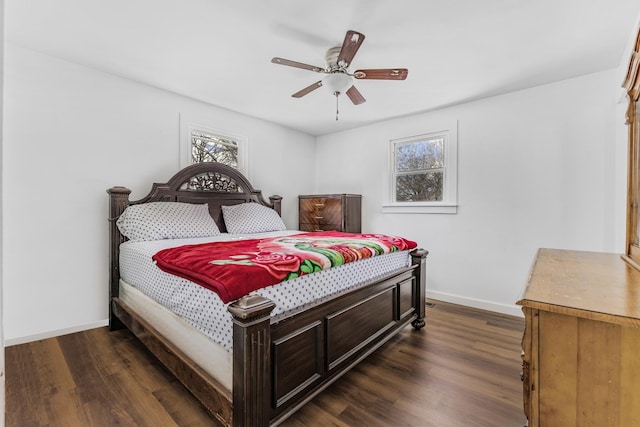 bedroom with dark wood-style floors, ceiling fan, and baseboards